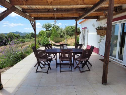 a dining table and chairs on a patio at Cal Velho - Holiday Lodge in São Luis
