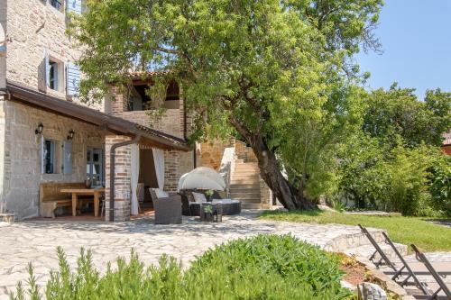 un patio davanti a una casa con un albero di Villa Stefani a Buje