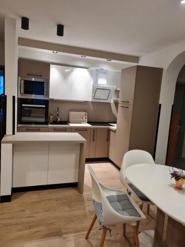 a kitchen with a table and a table and chairs at Apartman M.I.R.A. in Cres