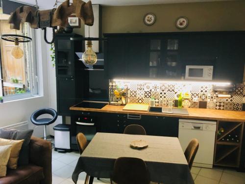 une cuisine avec une table en face d'un comptoir de cuisine dans l'établissement Cocon de la Vallée d'Ossau , Véritable Havre de paix - 4 à 6 pers, à Eaux-Bonnes