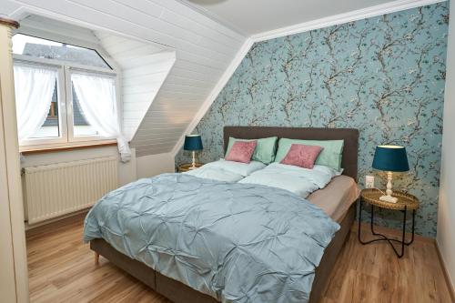 ein Schlafzimmer mit einem Bett und zwei Tischen mit Lampen in der Unterkunft Ferienwohnungen Eifelstuben mit Charme - am See, nahe Burg in Ulmen