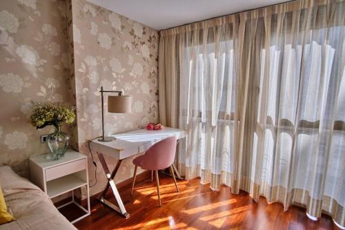 - une chambre avec un bureau, un lit et une fenêtre dans l'établissement Apartamento Plaza España, à Saragosse