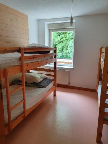 a room with two bunk beds and a window at Gîte du Moulin in Les Planches-près-Arbois