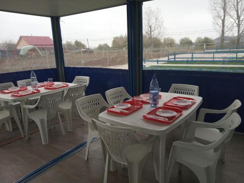 two tables and chairs on a porch with a view of a field at Camping Danubius Tulcea in Tulcea