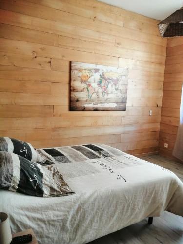 un lit dans une chambre avec un mur en bois dans l'établissement LES FARIOS AVEC TERRASSE, à Sarlat-la-Canéda
