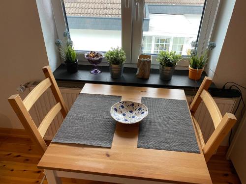 a wooden table with two chairs and a bowl on it at Werners Doppelzimmer in Insul