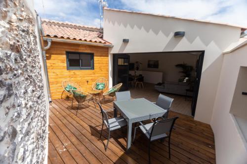 une terrasse en bois avec une table et des chaises. dans l'établissement Maison l'Estrella, à Marseillan
