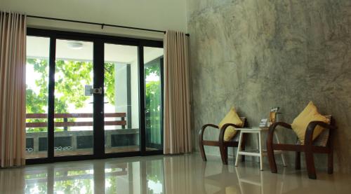 a room with a table and chairs and a window at Jamjuree Home at Udonthani in Udon Thani