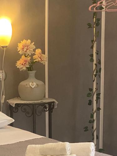 a vase with flowers on a table in a bedroom at B&B Central Station Suite in Naples
