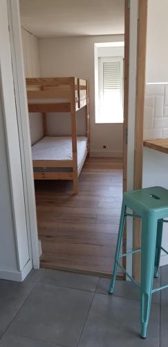 a room with two bunk beds and a green stool at Gîte Lucian Mont-saint-michel in Moidrey