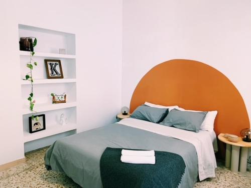 1 dormitorio con 1 cama grande y cabecero naranja en Maria Magdalena - Room 3, en Málaga