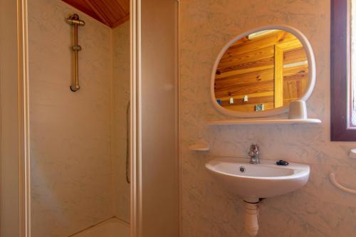 a bathroom with a sink and a mirror at Domki Nad Potokiem in Polańczyk