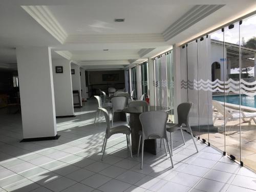 a dining room with tables and chairs and a pool at Praia dos Carneiros apart beira-mar in Tamandaré