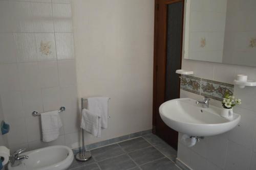 a bathroom with a sink and a toilet and a mirror at Scilla A Vinedda in Scilla