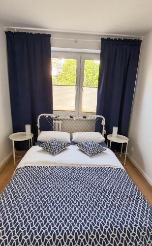 sypialnia z niebiesko-białym łóżkiem i 2 oknami w obiekcie Apartament Kurka w Hajnówce