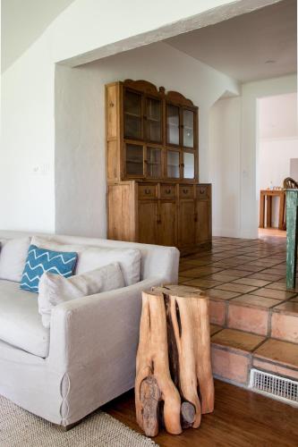 a living room with a couch and some logs at Contigo Ranch Fredericksburg in Fredericksburg
