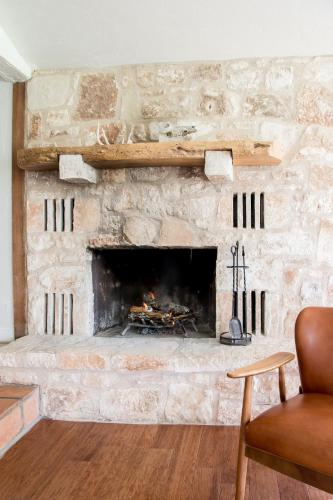 a living room with a stone fireplace at Contigo Ranch Fredericksburg in Fredericksburg