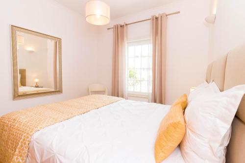 a bedroom with a bed with a mirror and a window at ALzira By Rossio in Albufeira