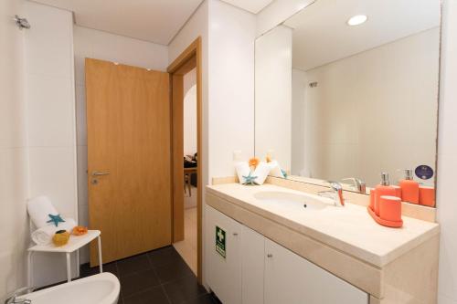 uma casa de banho com um lavatório, um WC e um espelho. em ALzira By Rossio em Albufeira