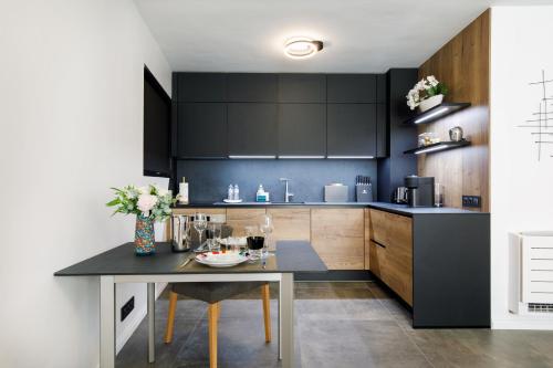 a kitchen with black cabinets and a dining table at Cannes CROISETTE, Palais des Festivals, Beaches, Apart Residence Le MINERVE in Cannes