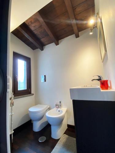 a white bathroom with a toilet and a sink at Casale Pratoterra in Bracciano