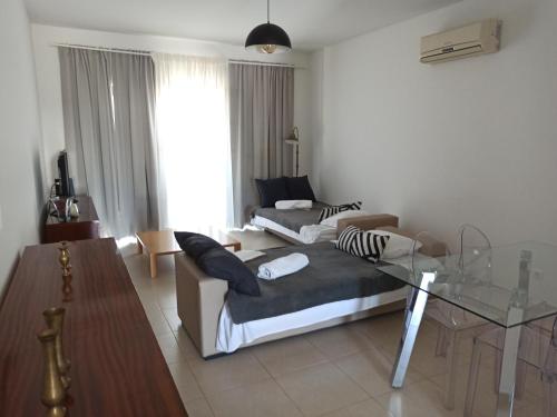 a living room with a couch and a glass table at ACC Apartamento T1 Palmela Village in Palmela