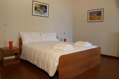 1 dormitorio con 1 cama con toallas en L'Oleandro en Loreto Aprutino