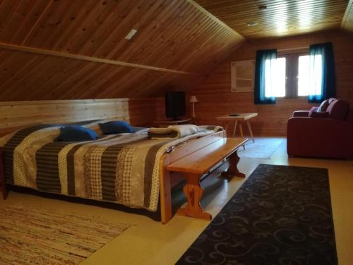 ルオストにあるVilla Wästä-Räkkiの木製の天井のベッドルーム1室(大型ベッド1台付)