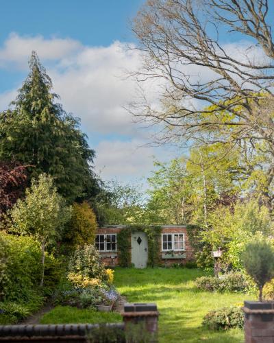 a house in the middle of a garden at Large Luxury Solihull 5 Bedroom House - The Residence - Close to NEC - Sleeps 9 in Solihull