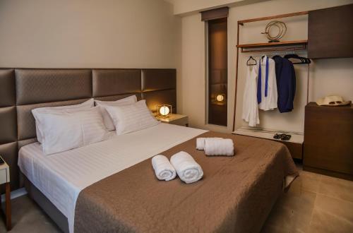 a bedroom with a bed with two towels on it at L-Suites in Kavála
