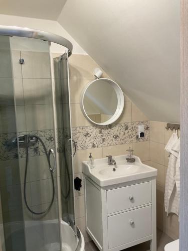 a bathroom with a shower and a sink and a mirror at Apartamenty u Kasi in Kudowa-Zdrój