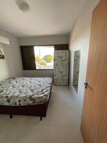 um quarto com uma cama, uma janela e uma porta em Apartamento Florianópolis ponta das canas em Florianópolis