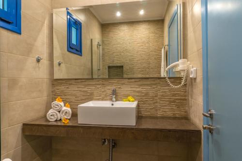 a bathroom with a sink and a mirror at Hotel Loukas Vrachos in Paralia Vrachou