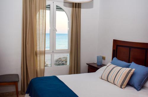 チクラナ・デ・ラ・フロンテーラにあるApartamento Barrosaplaya1のベッドルーム1室(ベッド1台、海の景色を望む窓付)が備わります。
