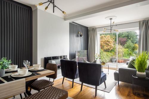 a dining room and living room with a table and chairs at Large Luxury 5 Bedroom Solihull House, Sleeps 9 - Close to NEC, Birmingham BHX Airport in Solihull