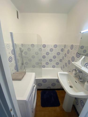 łazienka z umywalką, toaletą i wanną w obiekcie Appartement 50m2 en duplex w mieście Le Grau-du-Roi