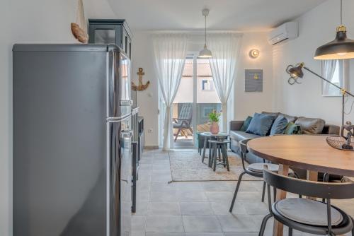 eine Küche und ein Wohnzimmer mit einem Kühlschrank und einem Tisch in der Unterkunft New and chic place near Old Town of Trogir in Trogir