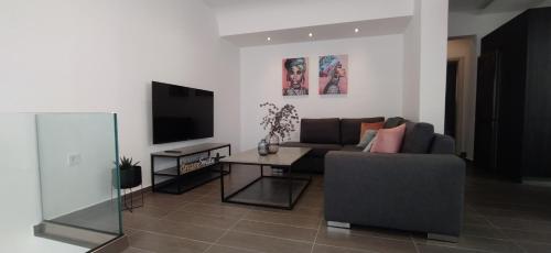 a living room with a couch and a tv at Rodini Inn in Rhodes Town