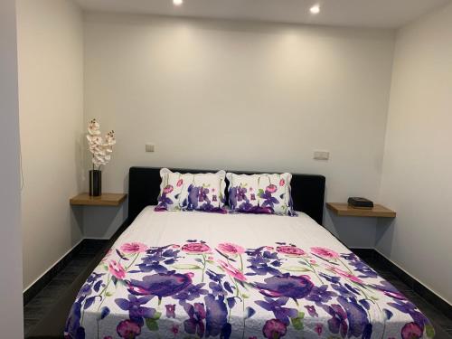 a bedroom with a bed with a floral bedspread at Casa da Ruela no Rodo in Peso da Régua