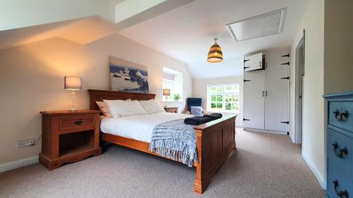 1 dormitorio con cama, escritorio y ventana en Glenfield Cottage - Secluded Luxury deep in the Oxfordshire Countryside, en Wilcote