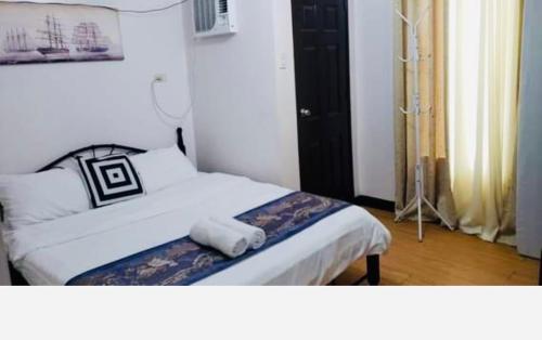 a bedroom with a bed with a towel on it at Estien’s cozy condo to stay with kitchen in Manila