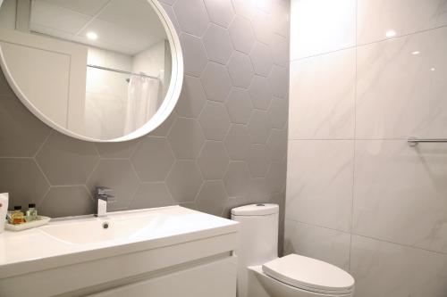 a bathroom with a toilet and a sink and a mirror at Auberge du Grand Lac in Magog-Orford
