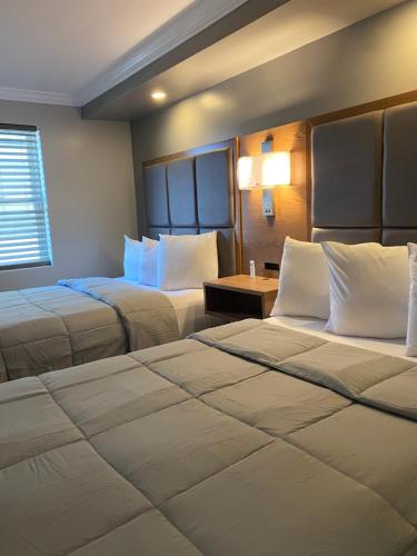 a hotel room with two beds and a window at Coastal Sands Inn in Wildwood
