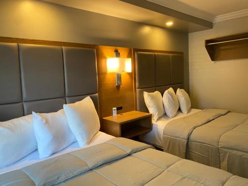 a hotel room with two beds with white pillows at Coastal Sands Inn in Wildwood
