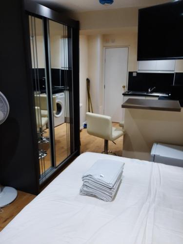 a pile of towels sitting on a bed in a room at Budget Ensuite Room in Thamesmead in London
