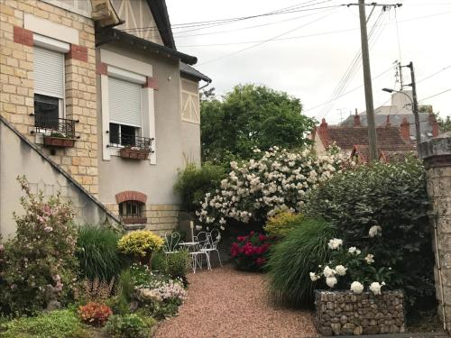 a garden in front of a house with flowers at Chambre d'hôtes Le Cadran des Chauvelles in Nevers