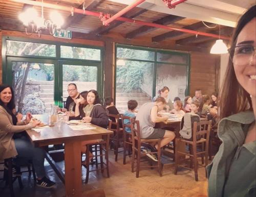een groep mensen die aan tafel zitten in een restaurant bij The Riders' Experience - Glamping and Attractions Park- Full Board in Bet Oren
