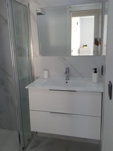 W białej łazience znajduje się umywalka i lustro. w obiekcie Chalet Pôr do Sol w mieście Castro Daire