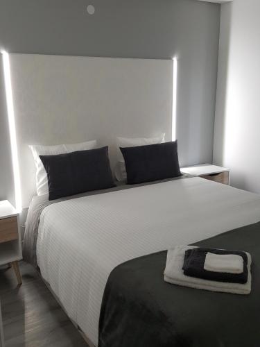um quarto com uma grande cama branca com uma toalha em Chalet Pôr do Sol em Castro Daire