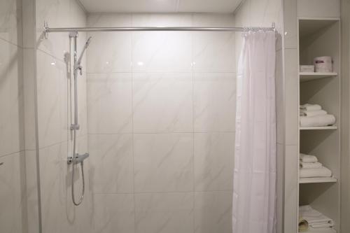 a bathroom with a shower with a shower curtain at Auberge du Grand Lac in Magog-Orford